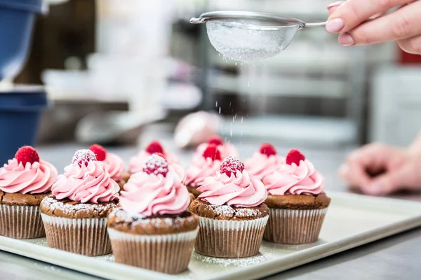Frau in Süßwaren-Zuckerguss-Cupcakes — Stockfoto