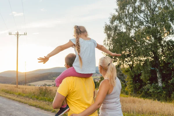 Familie trägt Kind huckepack — Stockfoto