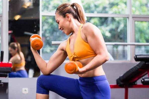 Young woman shaping biceps — Stock Photo, Image