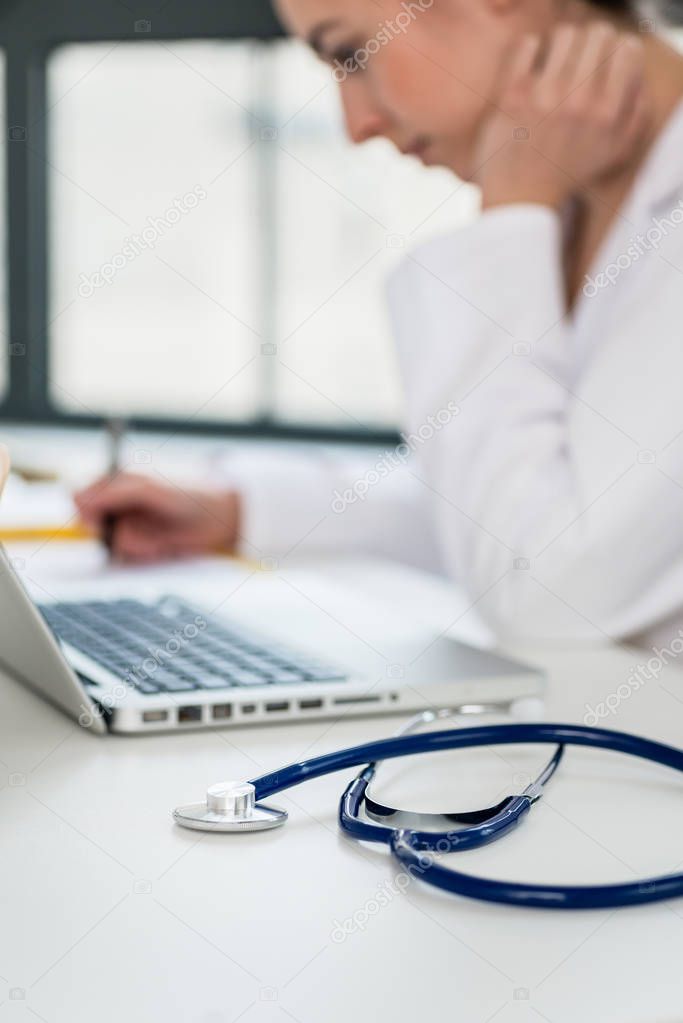 female physician typing on laptop