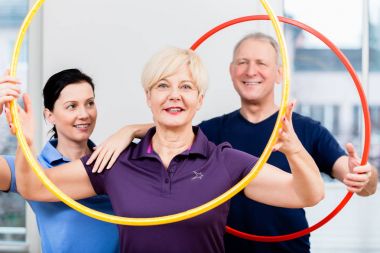 Üst düzey iki hula hoop ile egzersiz yaparak fizyoterapi içinde