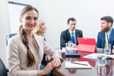 Portrait of a beautiful business woman looking at camera during meeting clipart