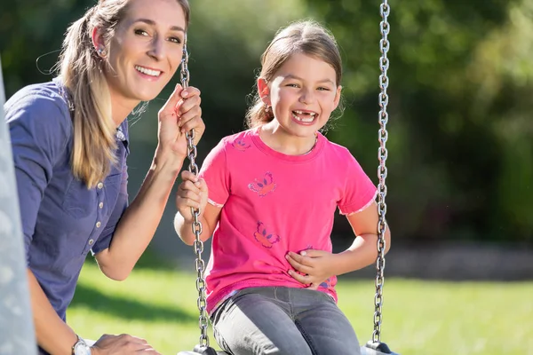 Donna con ridere ragazza su swing divertirsi insieme — Foto Stock
