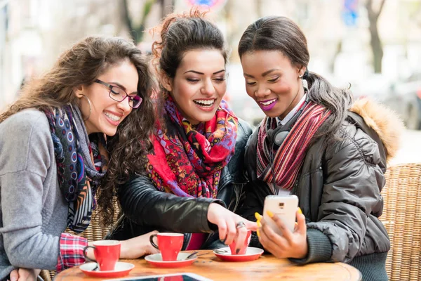 Mujeres en la cafetería mostrando fotos en el teléfono inteligente —  Fotos de Stock