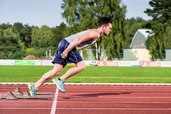 Atleet op cinder spoor van sport faciliteit begint aan sprint — Stockfoto