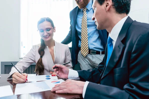 Analista de negocios sonriendo mientras interpreta informes financieros —  Fotos de Stock