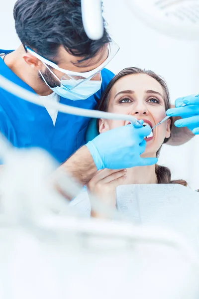 Piękna młoda kobieta patrząc w górę złagodzone podczas bezbolesny zabieg dentystyczny — Zdjęcie stockowe