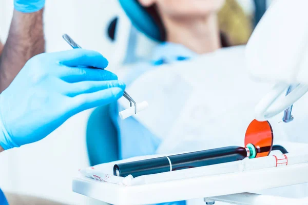 Primer plano de la mano de un dentista que prepara un curado led dental — Foto de Stock