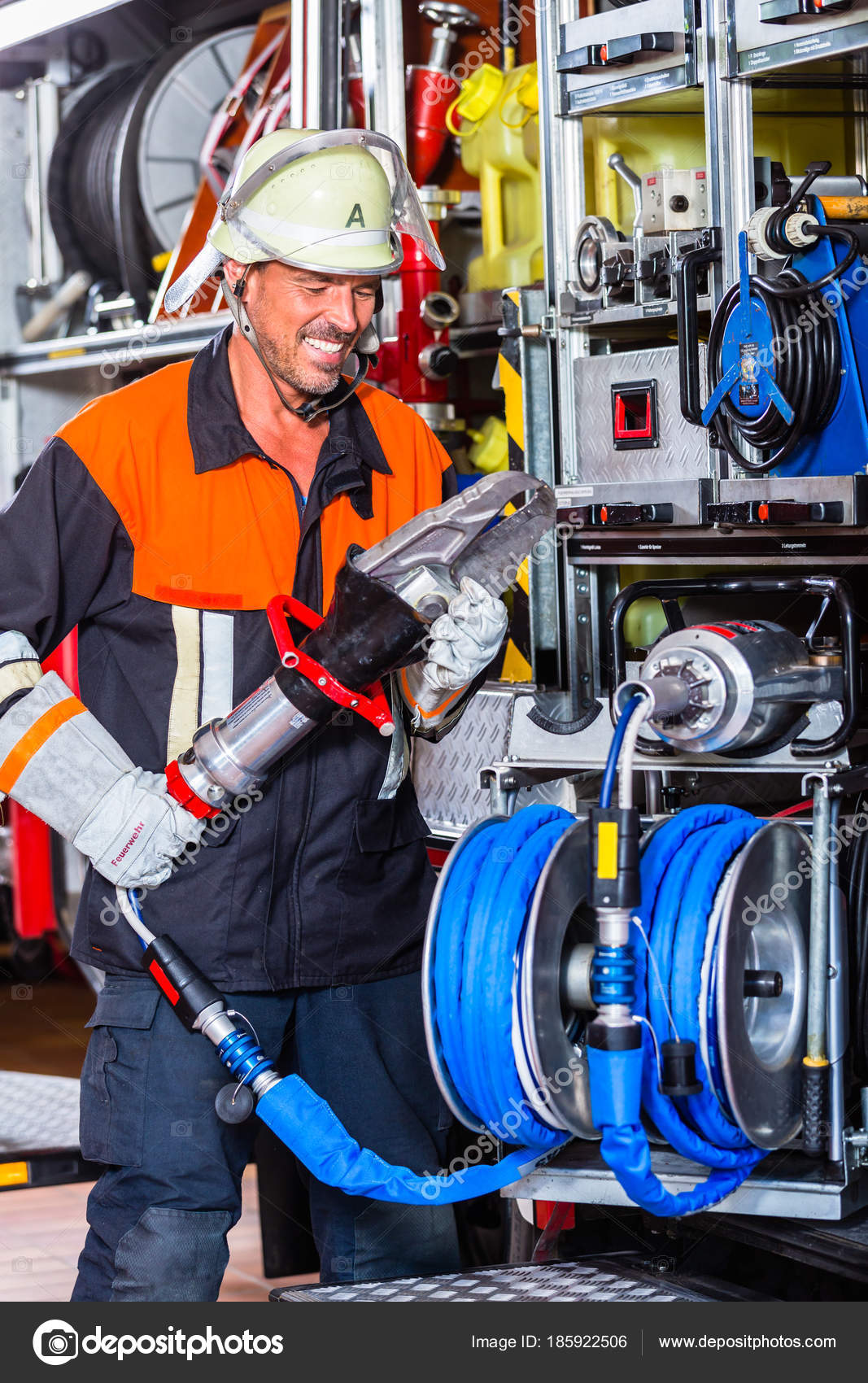 Fire fighter checking hydraulic cutter at fire engine — Stock Photo © Kzenon 185922506