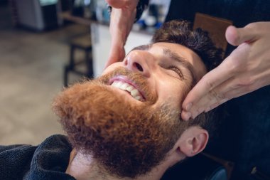 Rahatlatıcı bir tapınak masaj sırasında gülümseyen adam genç sakallı