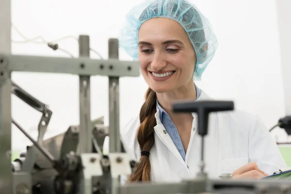 Retrato de mulher feliz técnico verificando equipamentos industriais — Fotografia de Stock