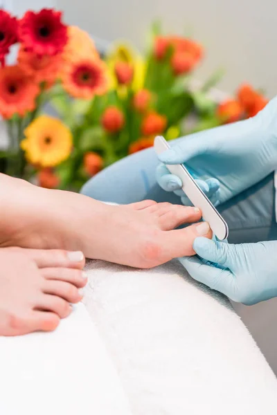 Gros plan des mains d'un technicien des ongles portant des gants chirurgicaux — Photo