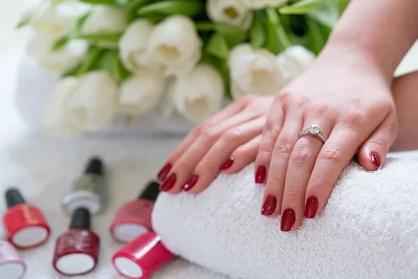 Primer plano de las manos de una joven con uñas rojas pulidas i — Foto de Stock