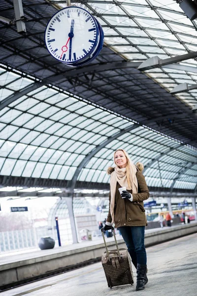 Frau schaut auf Uhr im Bahnhof, als ihr Zug Verspätung hat — Stockfoto