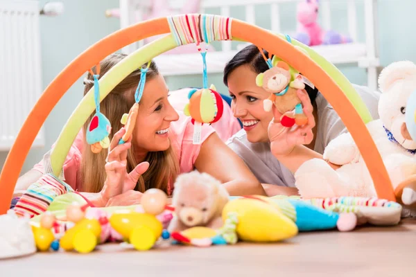 Women furnishing baby room preparing play bar for sucklings — Stock Photo, Image