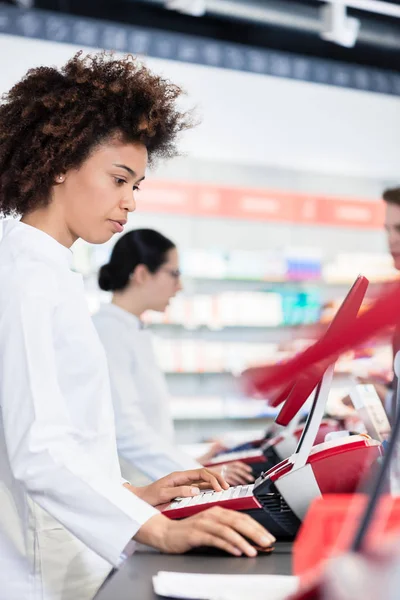 Alegre farmacéutico sosteniendo dos paquetes de medicamentos y dando consejos — Foto de Stock