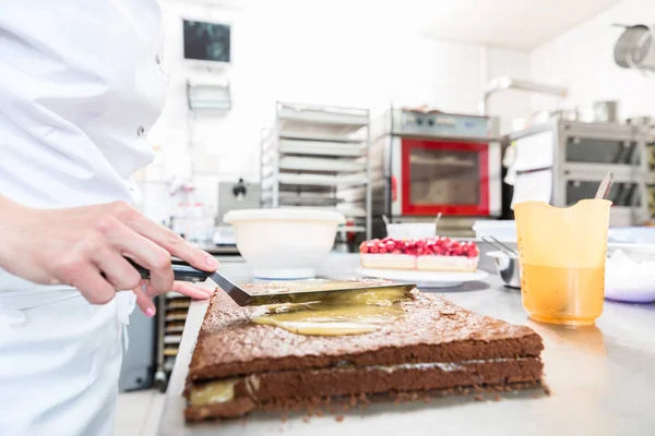 Confiseur femme obtenir gâteau au chocolat prêt avec garniture — Photo