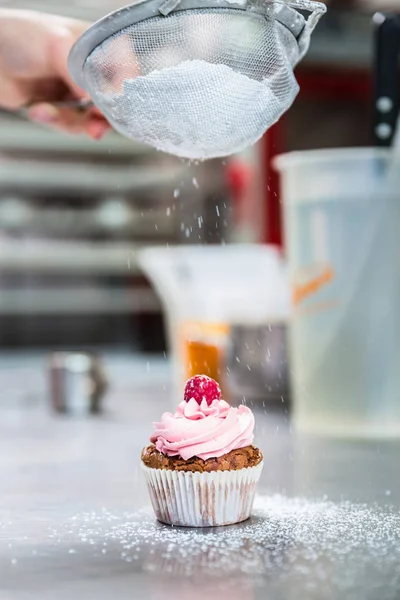 Mulher em confeitaria cupcakes de gelo com açúcar — Fotografia de Stock