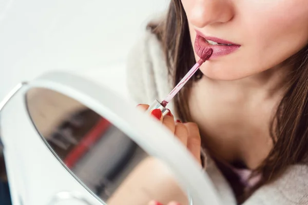 Vrouw toepassing van make-up en lippenstift — Stockfoto