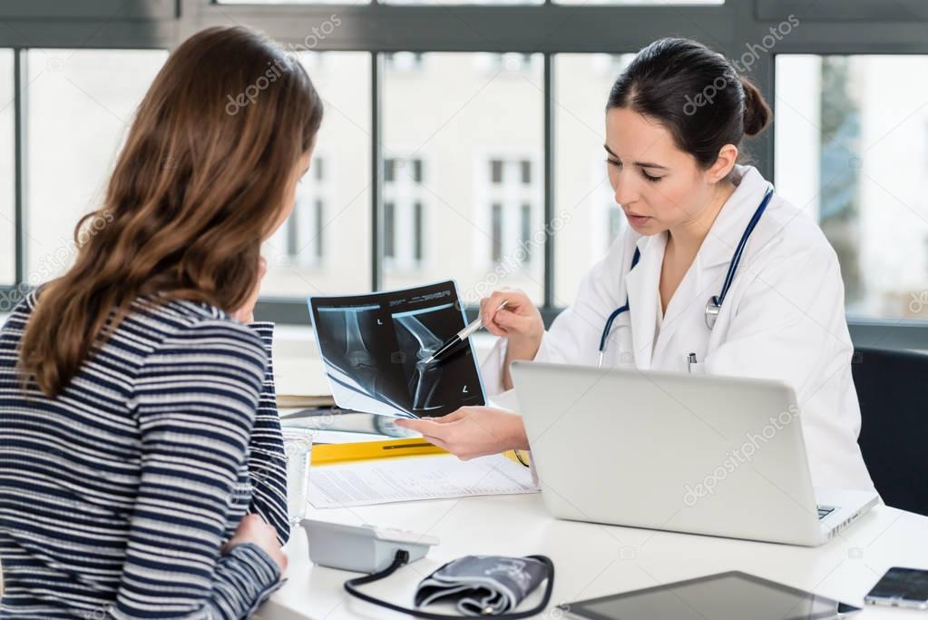Orthopedist explaining to her patient the pathology of the knee 