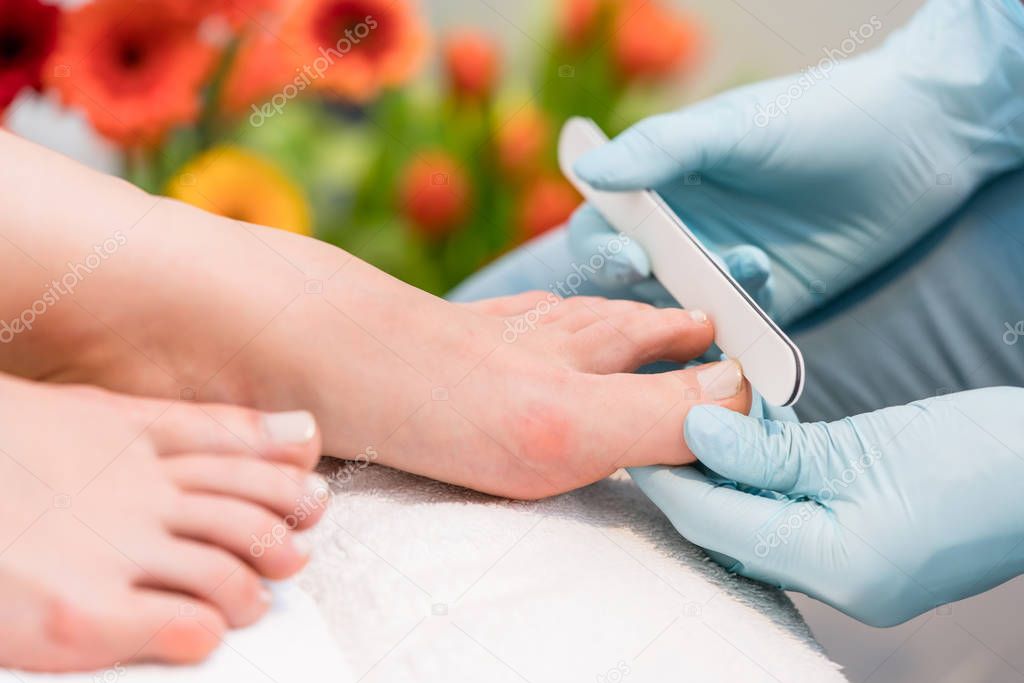 Close-up of the hands of a nail technician wearing surgical gloves
