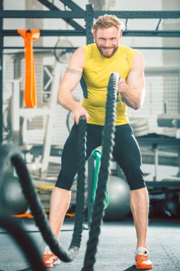 spor olarak yoğun fonksiyonel eğitim çalışma sırasında ağır savaş iplerle egzersiz vücut geliştirmeci