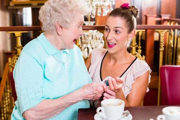 Senior vrouw en kleindochter op koffie in café — Stockfoto