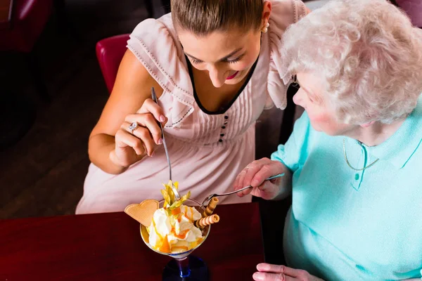 Grootmoeder en jonge vrouw eten van ijs — Stockfoto