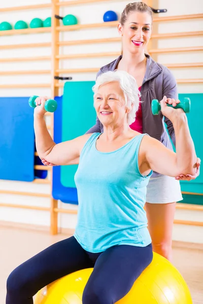 Donna anziana con allenatore nello sport fitness — Foto Stock