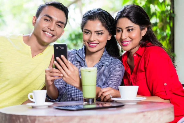 Indisk flicka visar bilder på telefon till vänner — Stockfoto