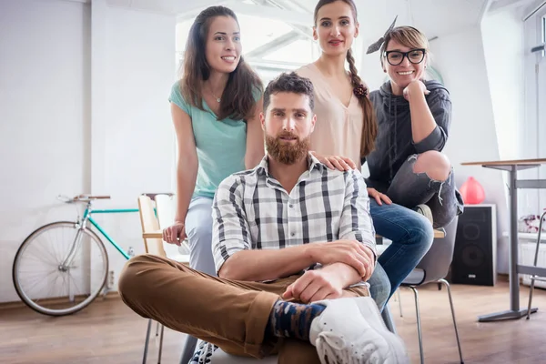 four co-workers wearing casual clothes during work in a modern hub