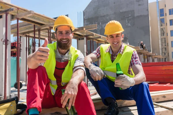 Twee jonge werknemers een koud biertje drinken tijdens pauze op werken — Stockfoto