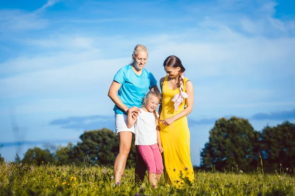 Deux femmes avec enfant dans une prairie — Photo