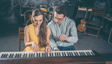 Piyano öğretmeni onun öğrencisi için müzik dersleri vermeye