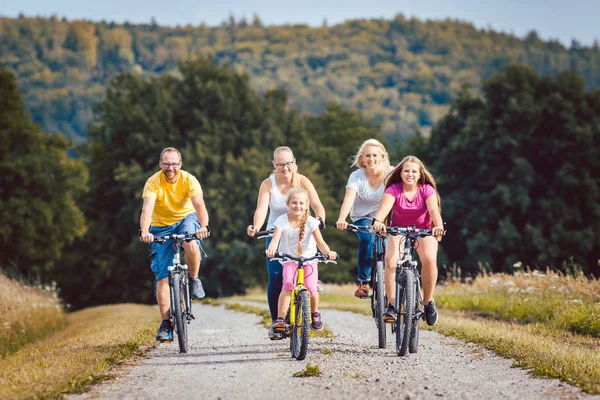 Familjen ridning sina cyklar på eftermiddagen på landsbygden — Stockfoto
