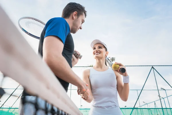 Tenis oyuncu adam ve kadın el sıkışma maçtan sonra — Stok fotoğraf