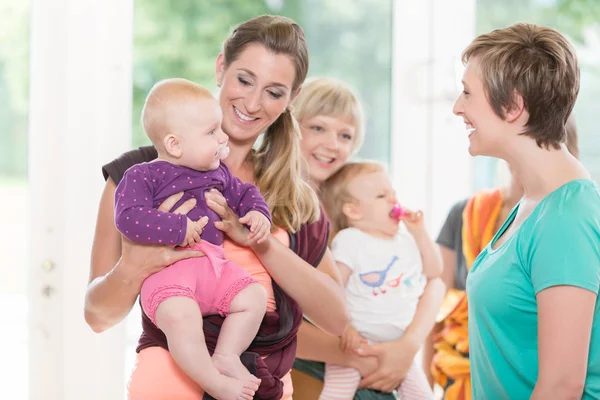Tanulás hogyan viselkedni használ baby heveder, az anya-gyermek nők csoportja — Stock Fotó