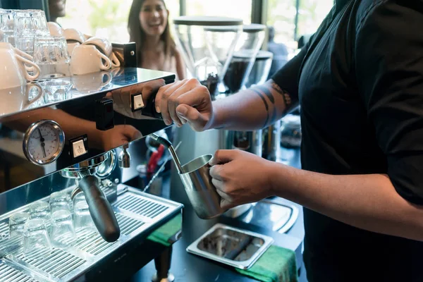 Hand eines Baristas mit einem Edelstahlbecher — Stockfoto