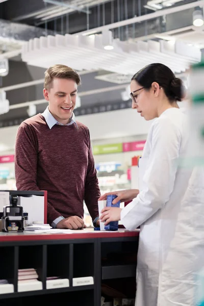 Cliente feliz escuchando las recomendaciones de un farmacéutico confiable — Foto de Stock