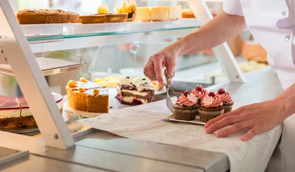 Bäckerin stellt Kuchen und Torten aus — Stockfoto