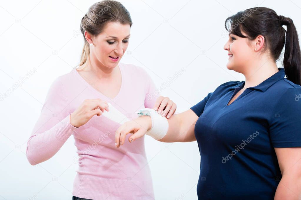 Women in First aid course learning to apply bandage