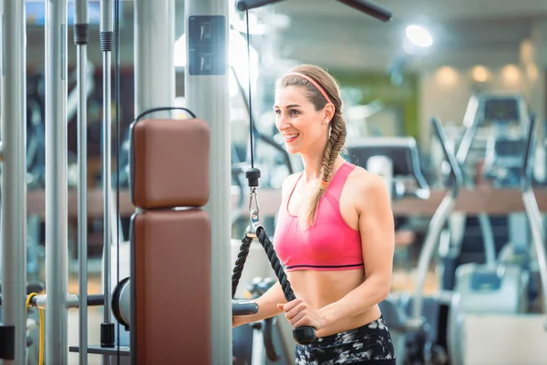 Mujer en forma feliz con sujetador rosa fitness mientras hace ejercicio —  Fotos de Stock
