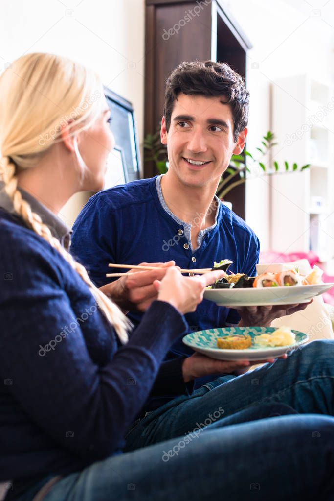 Portrait of happy young couple eating traditional Asian food