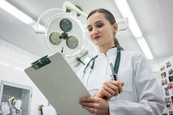 Doctor in de kliniek werking Theater met Klembord — Stockfoto