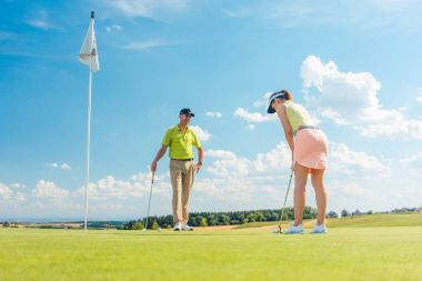 Kadın golf oyuncu topa vurmak hazır