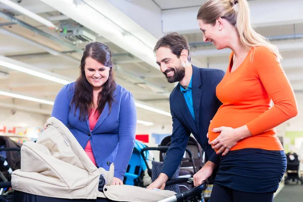 Mujer, hombre y dama de ventas en la tienda de bebés — Foto de Stock