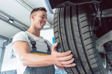 Bir lastiği tutan bir yetenekli otomatik mekanik el düşük açılı görünüş