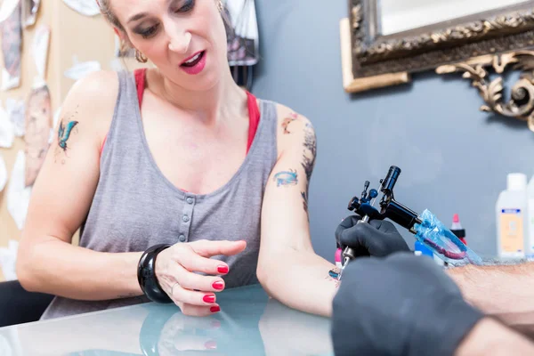 Közeli kép: a kéz egy tetováló művész egy színes pillangó árnyékolás — Stock Fotó