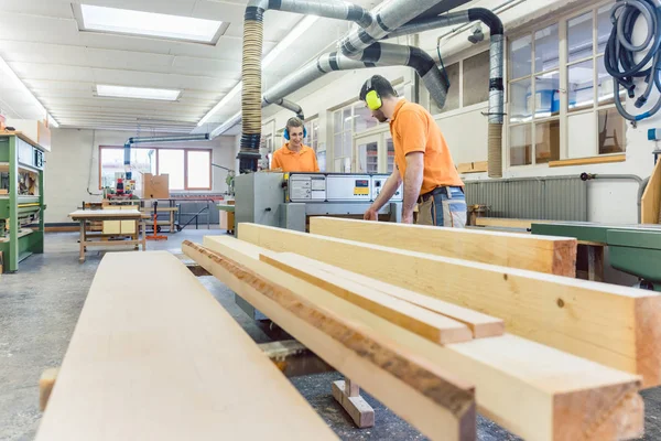 Carpintero o carpintero trabajando en troncos en su taller — Foto de Stock