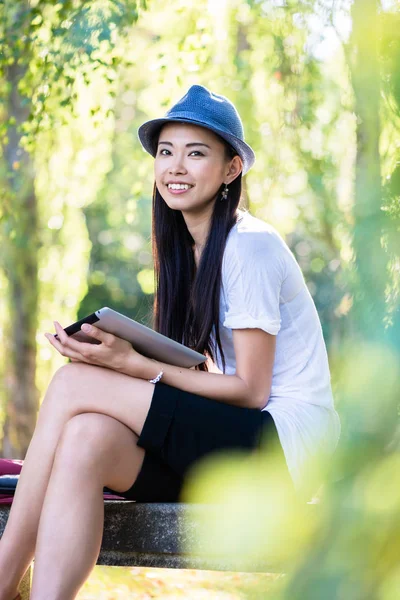 Asiatisk kvinna använder en tablet Pc utomhus — Stockfoto